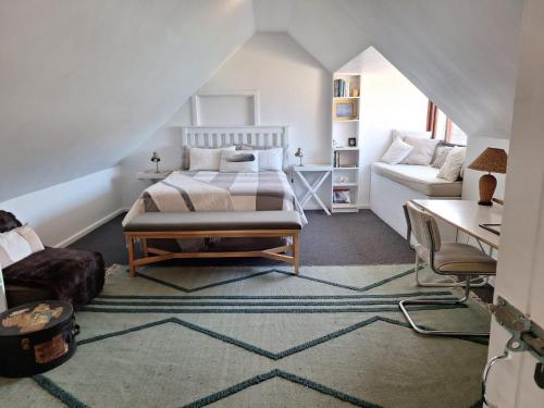 a bedroom with a bed and a couch at Uitkyk in Fish hoek