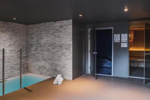 a room with a swimming pool and a brick wall at Heliopic Hotel & Spa in Chamonix