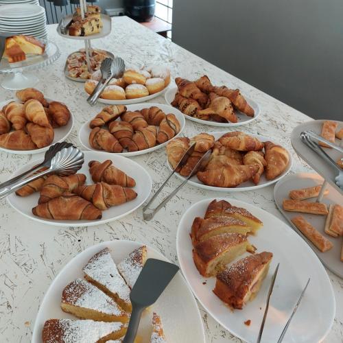 a table topped with plates of pastries and pastries at Hotel Helvetia in Grado