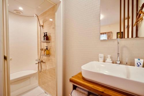a white bathroom with a sink and a shower at 遥華-Haruka House in Kyoto
