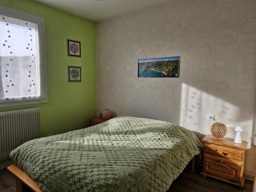 une chambre verte avec un lit et une fenêtre dans l'établissement Maison de Vacances, à Morbier