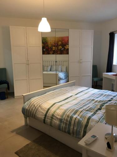 a bedroom with a bed and a mirror at NEW Apartment with sunset views and pool in Żebbuġ