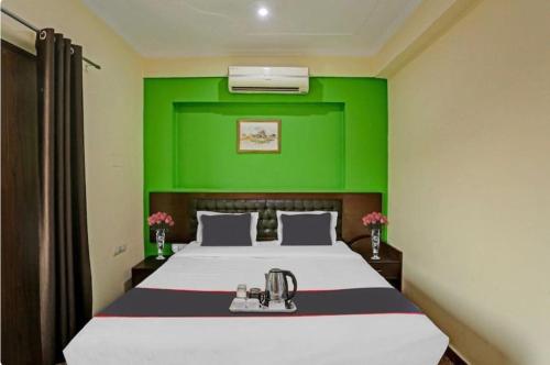 a bedroom with a bed with a green wall at Hotel Elite Stay in Gurgaon