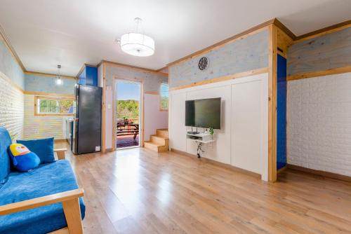 a living room with a blue couch and a tv at gochang sunonsan pungyeongpension in Gochang 