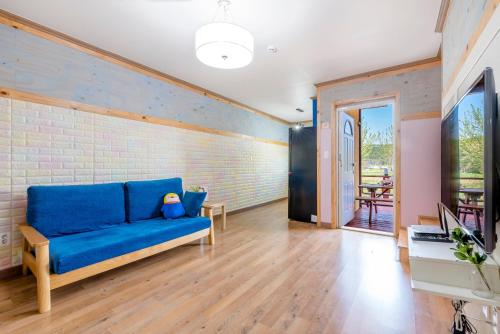 a blue couch in a room with a brick wall at gochang sunonsan pungyeongpension in Gochang 