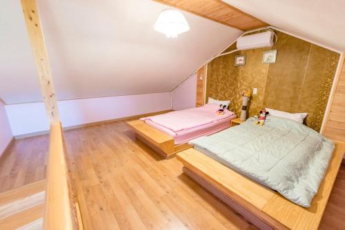 a bedroom with two beds in a attic at gochang sunonsan pungyeongpension in Gochang 
