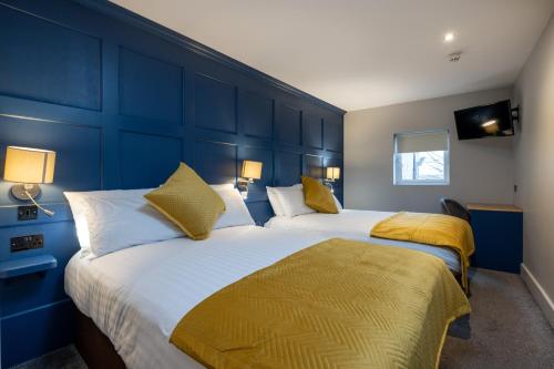 two beds in a room with blue walls at Ewings Bar & Self-Catering Accommodation in Carlow