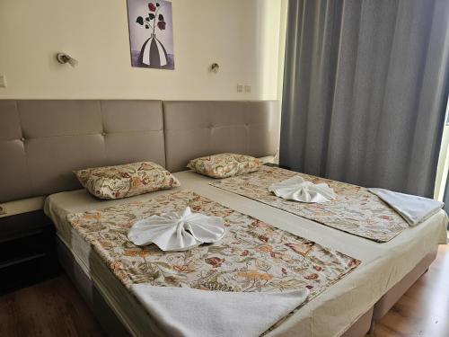 a bedroom with two beds with towels on them at Apartments Yalta in Golden Sands