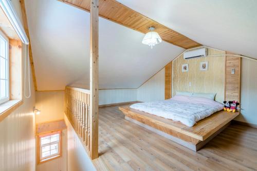 a bedroom with a bed in a attic at gochang sunonsan pungyeongpension in Gochang 