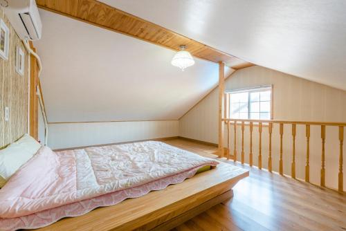 a bedroom with a bed in the attic at gochang sunonsan pungyeongpension in Gochang 