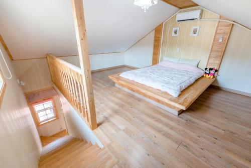 an attic bedroom with a bed and a staircase at gochang sunonsan pungyeongpension in Gochang 