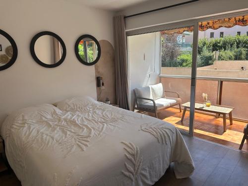 une chambre avec un lit et une vue sur un balcon dans l'établissement L'escapade salée - Saint Aygulf, à Fréjus