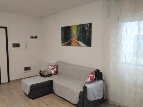 a living room with a couch and a painting on the wall at Lary&Giù in Cadelbosco di Sopra