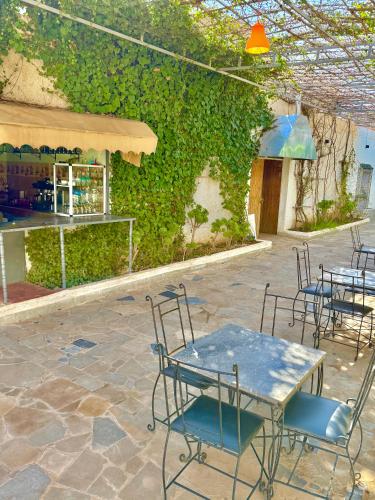 a patio with chairs and a table and a building at Hôtel Khalwa in Jenane Sidi Amer