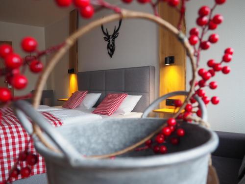 ein Schlafzimmer mit einem Bett mit roten Kissen und einer Pflanze in der Unterkunft Hotel Neumaier in Xanten