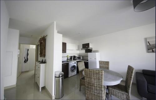 une cuisine et un salon avec une table et des chaises dans l'établissement T3 tout confort à 100m de la plage, Parking couvert gratuit, à Saint Pierre La Mer