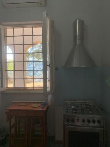 a kitchen with a stove and a table and a window at Apartment in villa Il Castellaccio in Poggio a Caiano