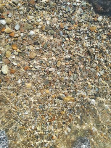 a bunch of rocks in the water at Aqua Blue villa in Loutrá Elevtherón