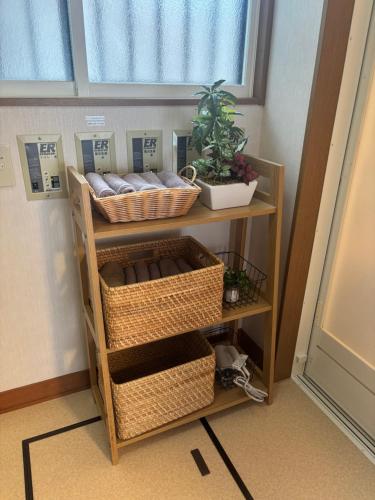 a room with two shelves with baskets and a window at 安曇野温泉おもいやりの湯 in Azumino