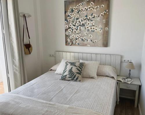a bedroom with a bed and a painting on the wall at Apartamentos Sa Barda - Emar Hotels in Sant Ferran de Ses Roques
