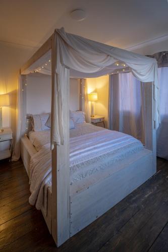 a bedroom with a white bed with a canopy at The Ridge London - Luxury Designer Villa with hot tub and sauna, Bexley borough of London in London