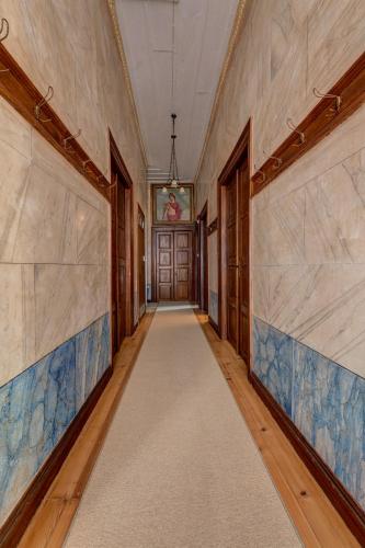 an empty hallway with blue and white tile walls at Palazzo Santa Maria - Historic Hotels of Europe in Ermoupoli