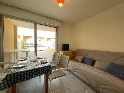 un salon avec une table et un canapé dans l'établissement Studio cabine avec terrasse spacieuse et parking à Sète - FR-1-338-147, à Sète