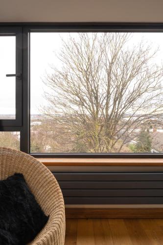 a window in a room with a chair and a tree at The Ridge London - Luxury Designer Villa with hot tub and sauna, Bexley borough of London in London