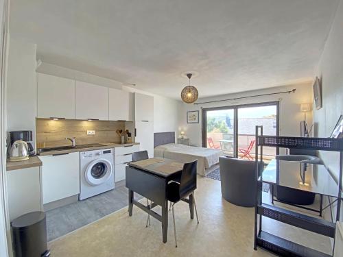 une cuisine et un salon avec une table et une salle à manger dans l'établissement Studio à Larmor-Plage: balcon, parking, à 500m de la mer et des commerces - FR-1-349-110, à Larmor-Plage