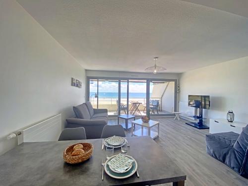 a living room with a view of the ocean at Spacieux studio terrasse, mer à 700m commerces, parking privé, Wi-Fi inclu - FR-1-349-116 in Larmor-Plage