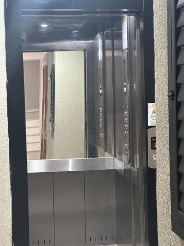 Puerta de cristal con espejo en una habitación en Lindo apartamento - 3 min da praia do recreio, en Río de Janeiro