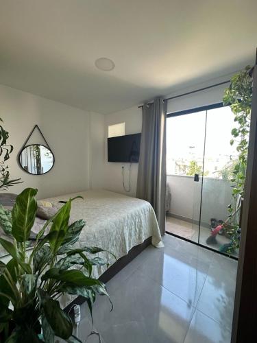 Un dormitorio con una cama y una ventana grande. en Lindo apartamento - 3 min da praia do recreio, en Río de Janeiro