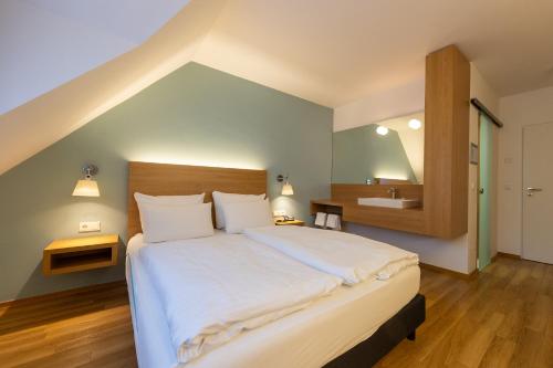 a bedroom with a large bed and a bathroom at Cuxlandhotel Doppelzimmer 111 in Dorum Neufeld