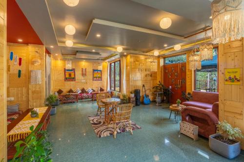 a living room with a couch and a table and chairs at Offbeat Pulga by Pack, near Kasol in Pulga