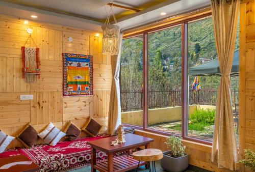 a room with a bed and a large window at Offbeat Pulga by Pack, near Kasol in Pulga