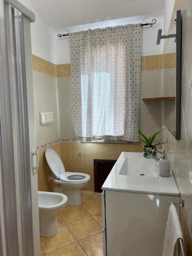 a bathroom with a white toilet and a sink at Villa Relais ALGHERO -Country Villa with Pool in Alghero