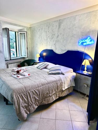 a bedroom with a large bed with a blue headboard at Good vibes penthouse Ca Lidia 5terreparco in Riomaggiore
