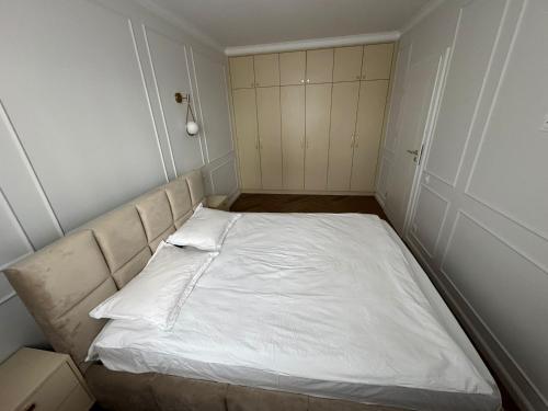 a small bedroom with a white bed in it at High Stay Suite Cluj in Floreşti