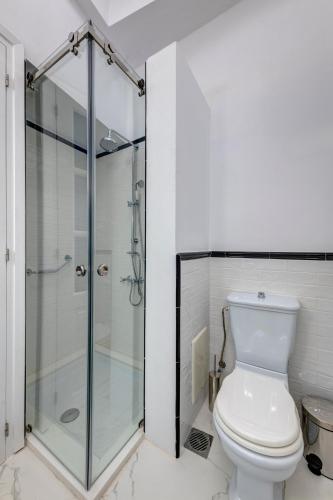 a bathroom with a toilet and a glass shower at Palazzo Santa Maria - Historic Hotels of Europe in Ermoupoli