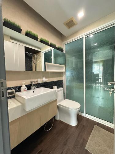 a bathroom with a white sink and a toilet at The Prim Grand Condo Wongamat N103 - Spacious apartment near the sea in Pattaya North