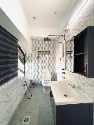 un baño con lavabo e inodoro en Hotel Casaria, en Paka