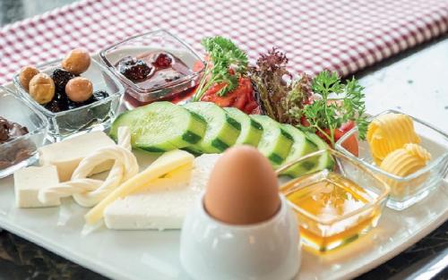 Un plato de comida con queso y verduras en una mesa. en Belek Deluxe Suit, en Belek