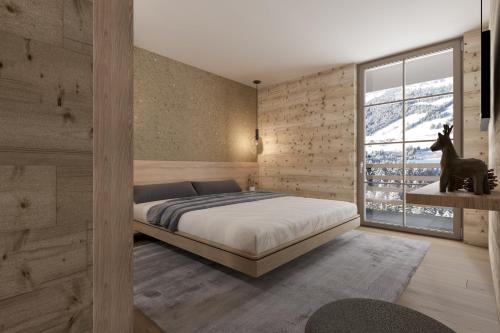 a bedroom with a large bed and a window at Berghotel Wald & Wiesn in Balderschwang