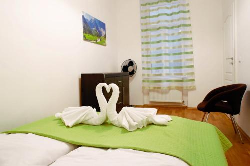 due cigni bianchi seduti sopra un letto di Prestige Vienna Apartment a Vienna