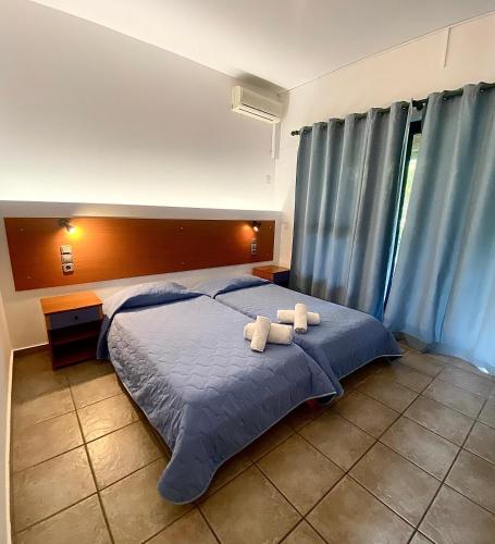 a bedroom with a bed with two teddy bears on it at Nireas Resort Corfu in Acharavi