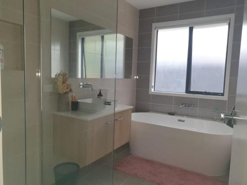 a bathroom with a tub and a sink and a bath tub at Melaleuca Homestay in Bahrs Scrub