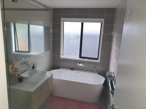 a bathroom with a large white tub and a sink at Melaleuca Homestay in Bahrs Scrub
