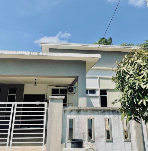 a house with a fence in front of it at Casaria Homestay Cherating in Kampong Baharu Cherating