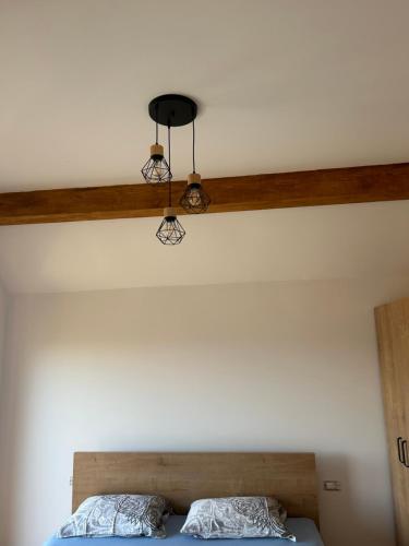 a bed with two pillows and two lights above it at Borl Apartment in Gradišča