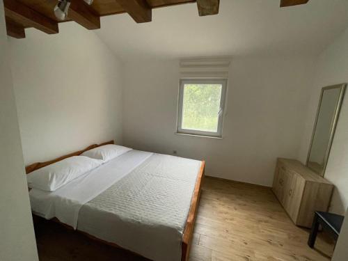 a bedroom with a white bed and a window at Amanda C in Starigrad